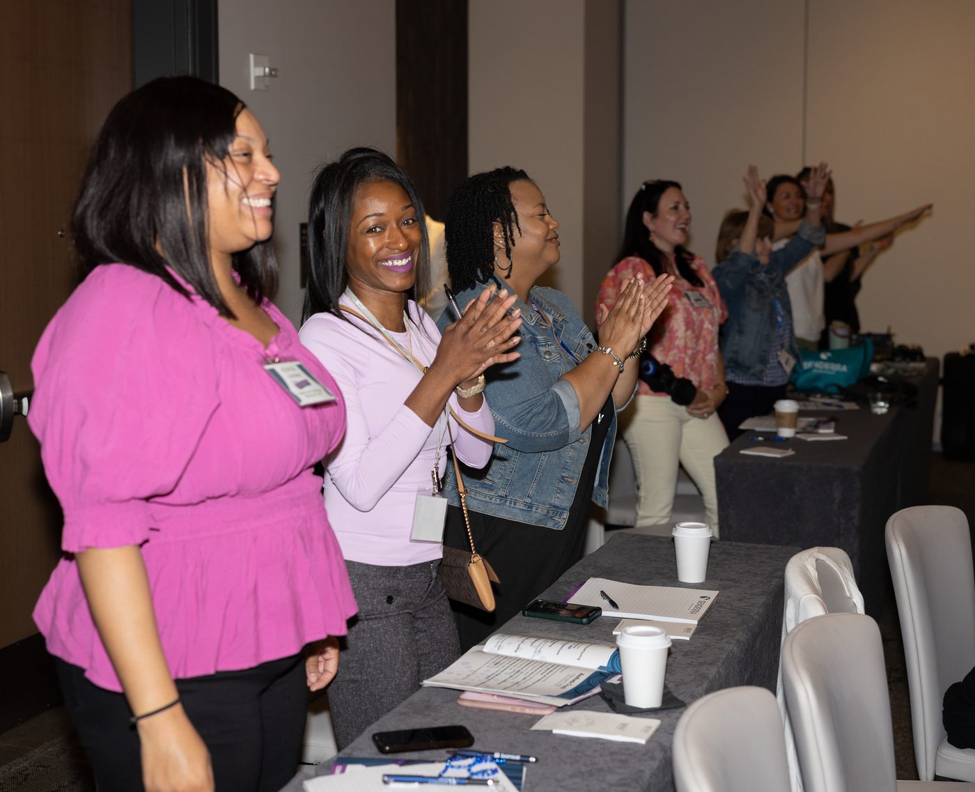 Attendees standing and applauding during a session