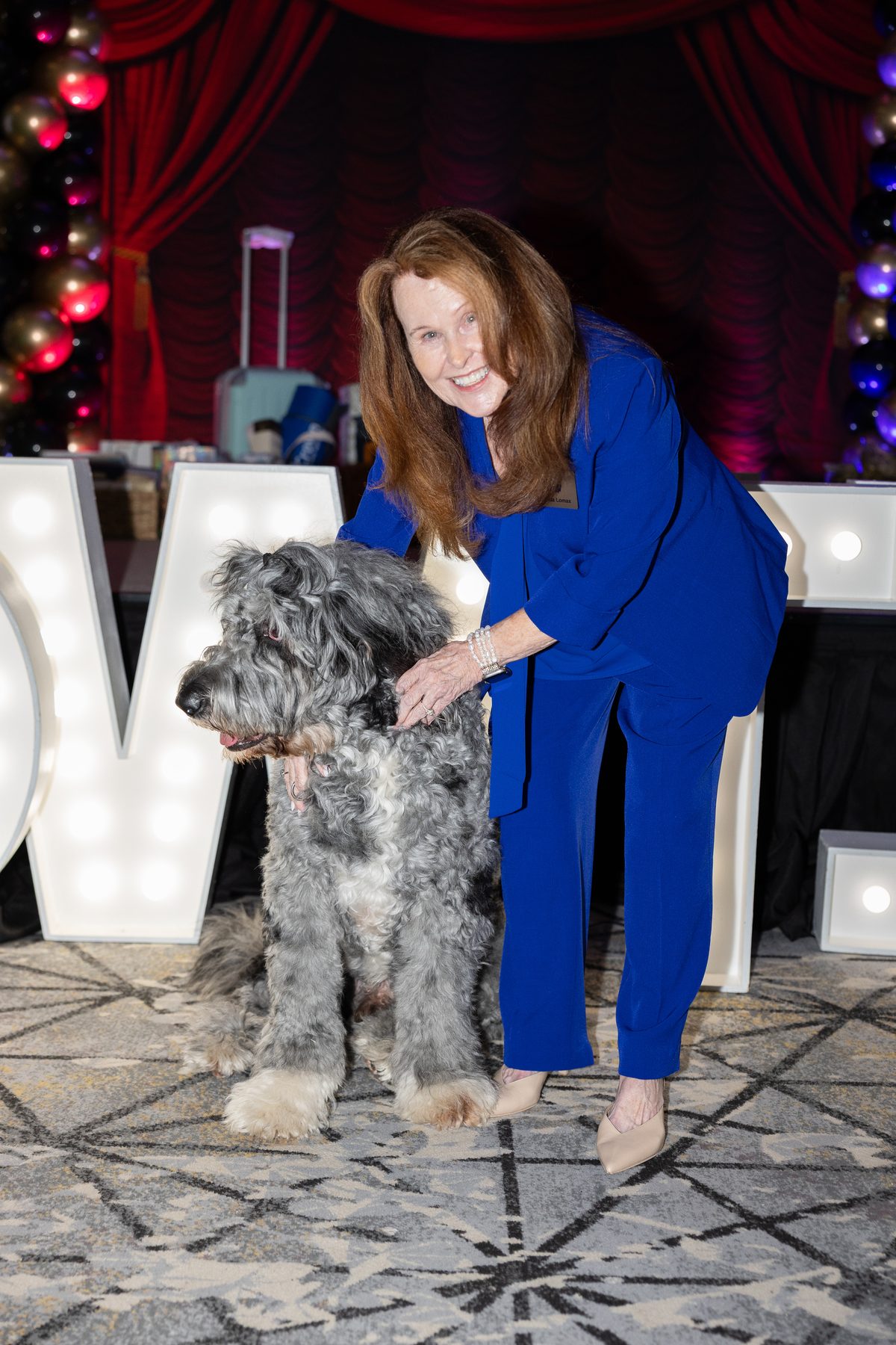 A returning attendee with a dog in front of the stage lights